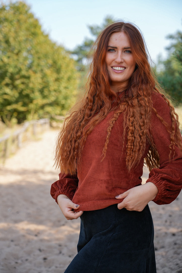 Nachhaltiger Pulli in rot-brauner Nuance mit leicht voluminösen Ärmeln für einen eleganten Stil.