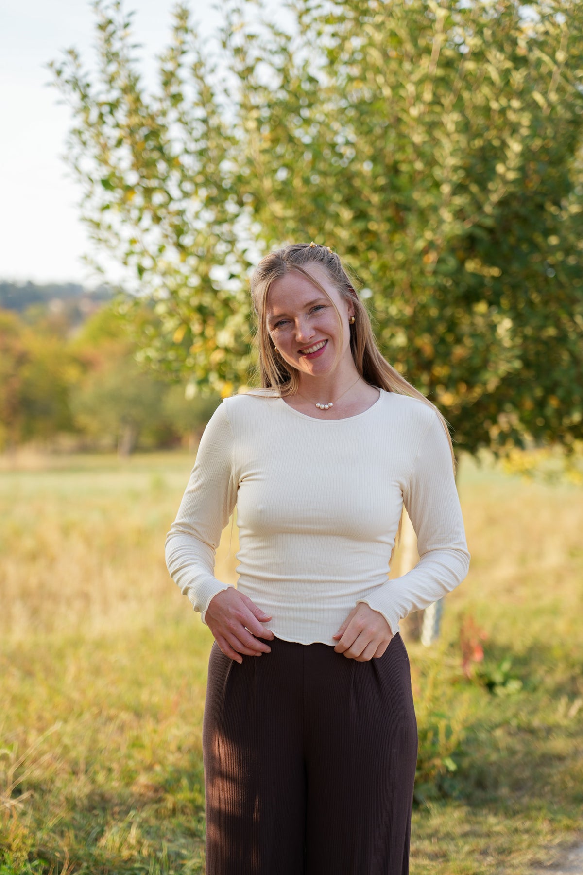 Wunderschönes weißes Langarmshirt für Damen mit verspieltem Rüschensaum und längerem Schnitt im angesagten Clean Girl Style