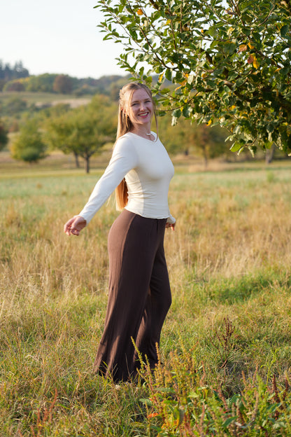 Wunderschönes nachhaltiges Langarmshirt in Muschelweiß mit Rundhalsausschnitt und verspieltem Rüschensaum für feminine Trend Outfits