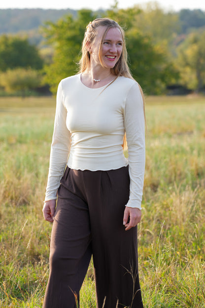 Nachhaltiges Damen Longsleeve in zartem Muschelweiß mit körperbetontem Schnitt und romantischen Rüschen im angesagten Clean Girl Style