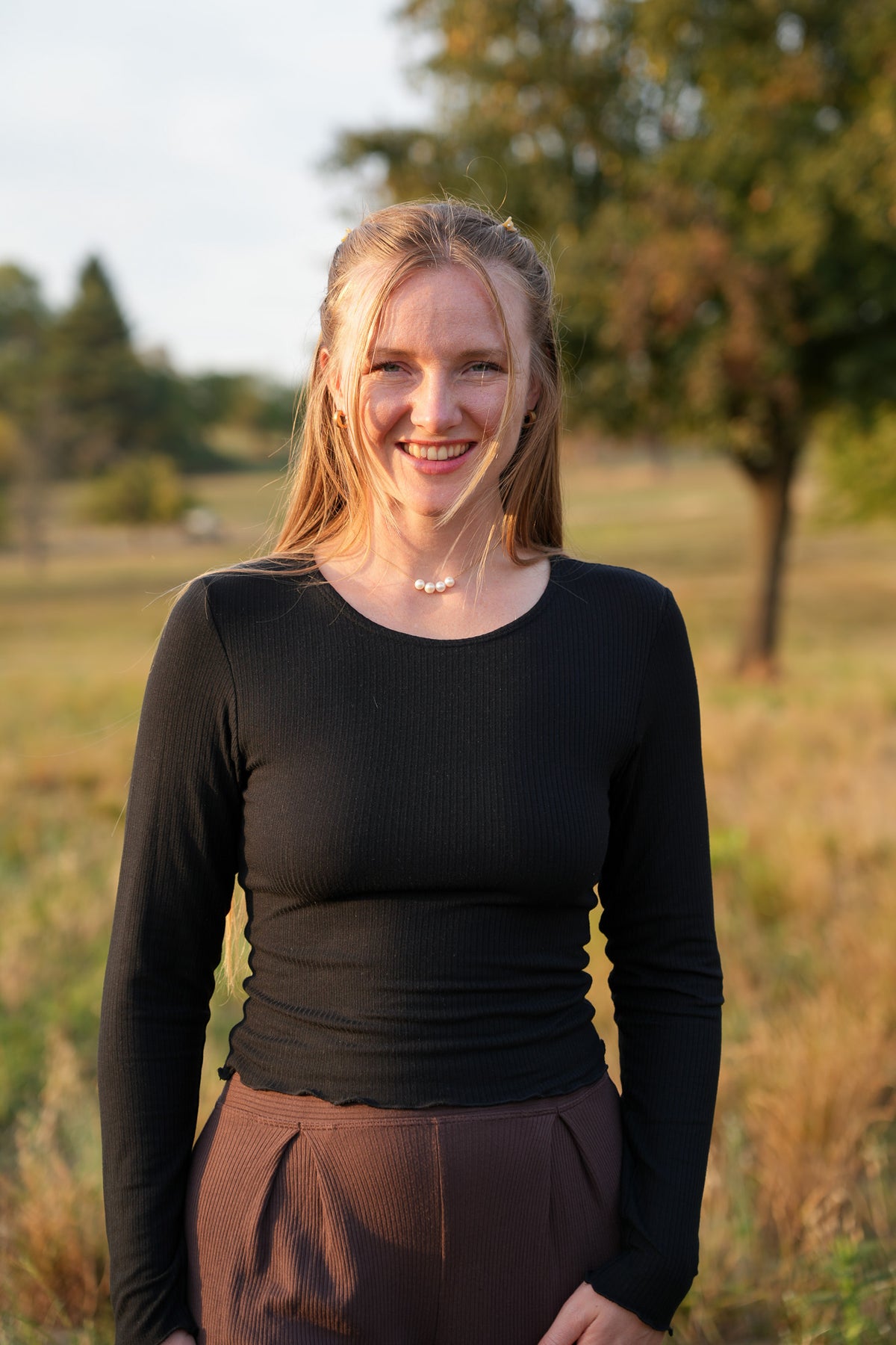 Wunderschönes figurbetontes Langarmshirt in Schwarz mit Rundhalsausschnitt und romantischem Rüschensaum für trendige Pinterest Looks