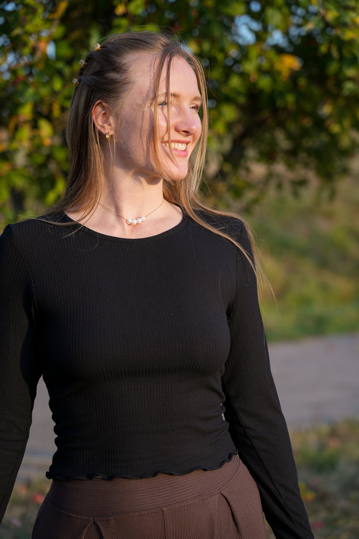 Moderner Pinterest Herbstlook mit nachhaltigem schwarzen Langarm Oberteil, femininem Rüschensaum und weichem anschmiegsamem Stoff
