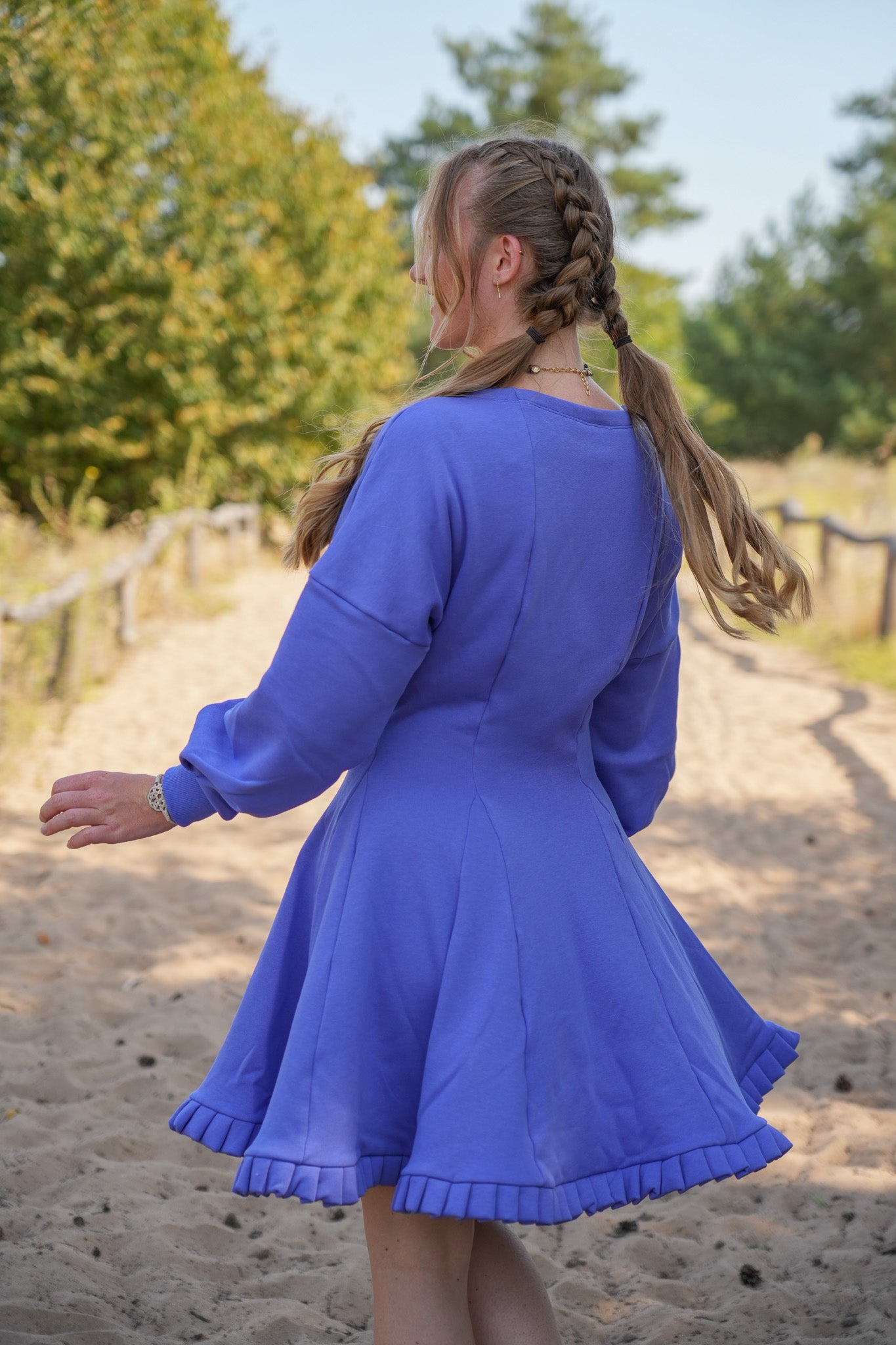 Stilvolles Winterkleid in tiefem Pflaumenblau, mit einem femininen, fließenden Rock.