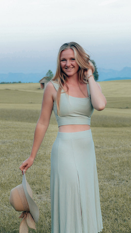 Nachhaltiger Midirock mit hoher Taille und Schlitz am Bein. In mintgrün und aus nachhaltigem Jersey mit Rüschen am Saum.